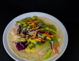 Ham, mozzarella cheese, and vegetables covered with honey mustard on flour tortilla