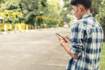 Asian man waiting for Uber taxi