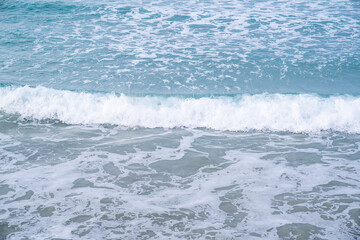 Naklejka na ściany i meble Soft blue ocean wave on sandy beach. Background textured.