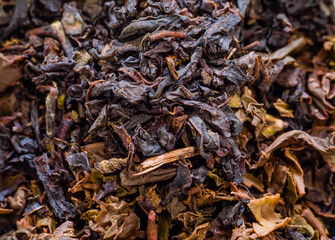 Extreme closeup of used and unused dry herbal tea leaves. Darker leaves have been used, lighter leaves after use.