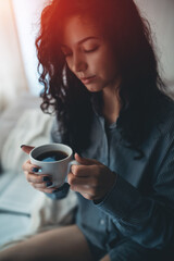 pretty brunette woman in morning bed with books and coffee