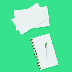 school notebook and papers on a green background, spiral notepad on a table
