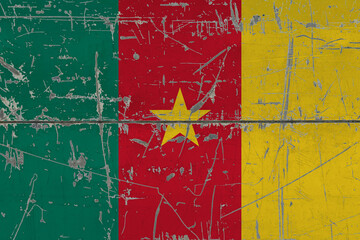 Cameroon flag painted on cracked dirty surface. National pattern on vintage style surface. Scratched and weathered concept.