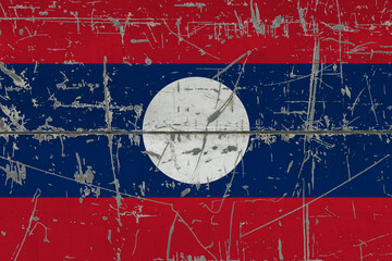 Laos flag painted on cracked dirty surface. National pattern on vintage style surface. Scratched and weathered concept.