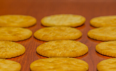 Round butter crackers on brown background.