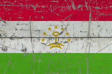 Tajikistan flag painted on cracked dirty surface. National pattern on vintage style surface. Scratched and weathered concept.