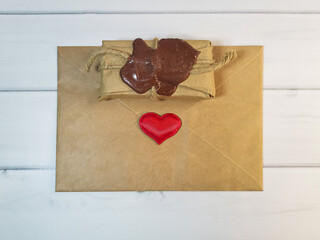 Delivery box tied with twine with a wax seal with an envelope from craft paper with a red heart. Concept: free delivery, gifts, vintage souvenirs, Love message, letter of recognition.