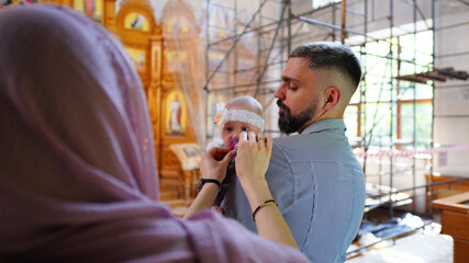 The sacrament of baptism. Christening the baby. Child and her godfather.