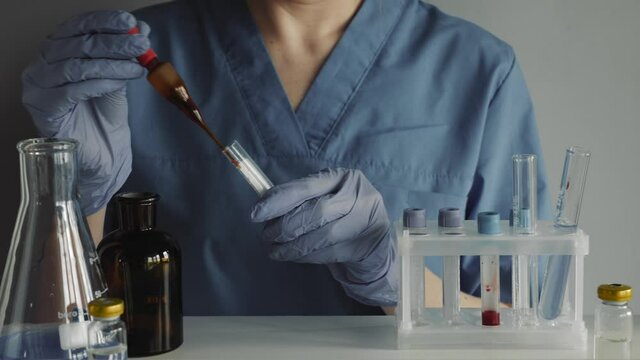 Scientist working in laboratory, processing of the laboratory sample in an Erlenmeyer flask, titration with reagent from a burette.