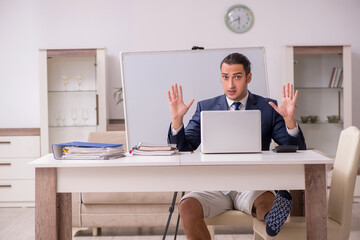 Young male employee working at home during pandemic disease