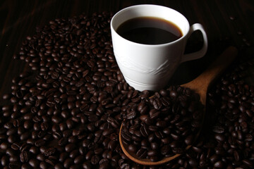 Coffee cup with beans on black table