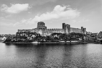Fototapeta premium Landscape with the ruins of Pembroke Castle on the shores of river Pembroke, the original family seat of the Earldom of Pembroke in Pembrokeshire, Wales, UK