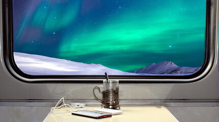 Coupe in a train overlooking the northern lights.