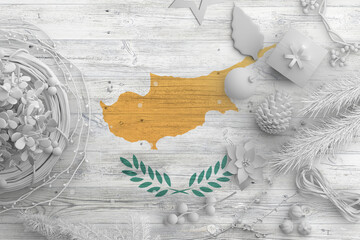 Cyprus flag on wooden table with snow objects. Christmas and new year background, celebration national concept with white decor.