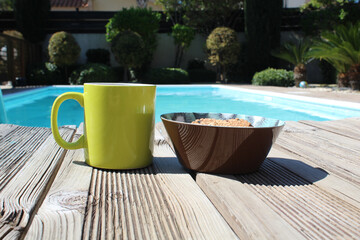 Fototapeta na wymiar A wholesome breakfast consisting of freshly squeezed juice and oatmeal cookies by the pool on a bright sunny morning