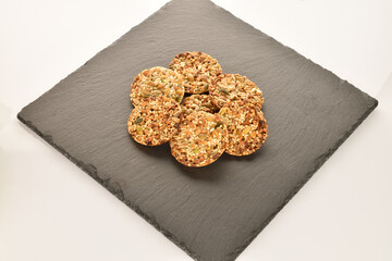 A few delicious walnut cookies, close-up, on a slate board.