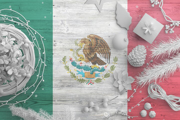 Mexico flag on wooden table with snow objects. Christmas and new year background, celebration national concept with white decor.