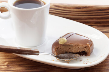 white cup with coffee with chocolate cupcake