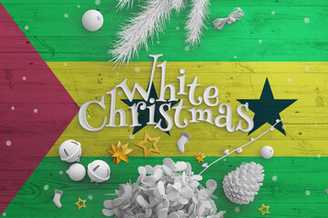 Sao Tome And Principe flag on wooden table with White Christmas text. Christmas and new year...