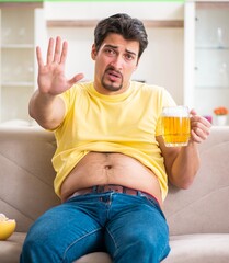 Fat obese man holding beer in dieting concept