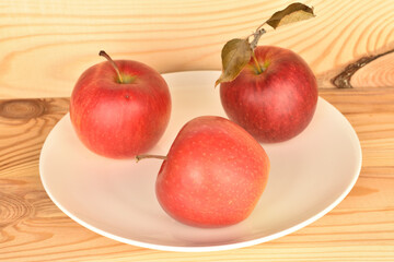 Ripe red apples, close-up, on a background of natural wood.