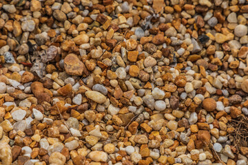 Close up of a pile of small rounded river rock pebbles commonly used for decoration in landscapes and garden flowerbeds as a mulch material