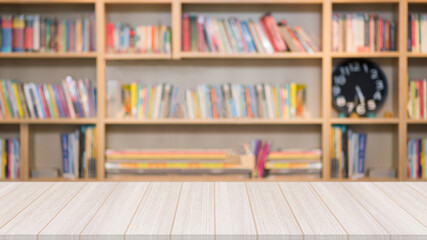 Wooden table in the library with a blurred bookshelf with many book in the background for education...