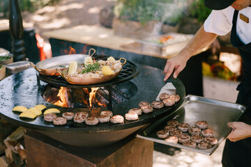 The chef grills meatballs for mini burgers on the grill. - obrazy, fototapety, plakaty