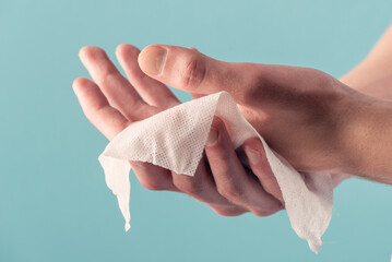 A man wipes his hands with a wet wipe