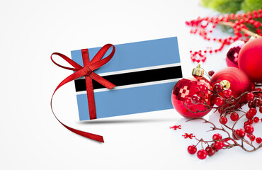 Botswana flag on new year invitation card with red christmas ornaments concept. National happy new year composition.