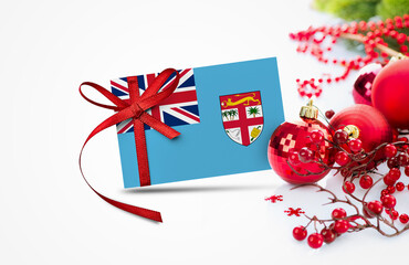 Fiji flag on new year invitation card with red christmas ornaments concept. National happy new year...