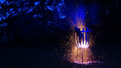 Fire basket with many sparks at night