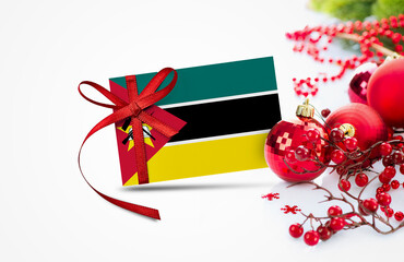 Mozambique flag on new year invitation card with red christmas ornaments concept. National happy new year composition.