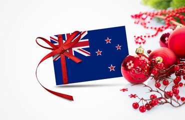 New Zealand flag on new year invitation card with red christmas ornaments concept. National happy new year composition.