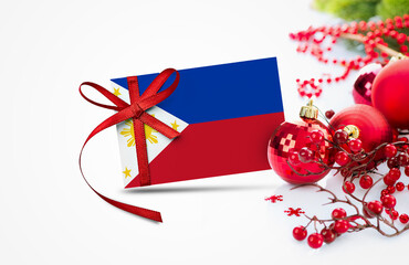 Philippines flag on new year invitation card with red christmas ornaments concept. National happy...