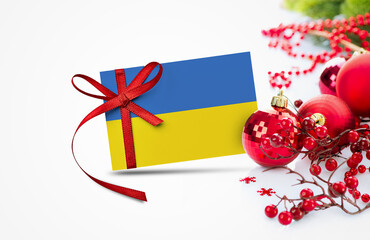 Ukraine flag on new year invitation card with red christmas ornaments concept. National happy new year composition.