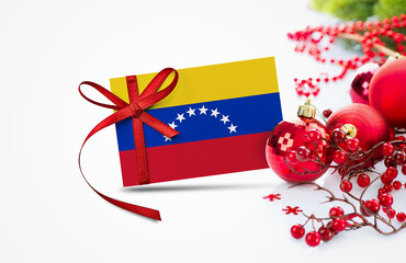 Venezuela flag on new year invitation card with red christmas ornaments concept. National happy new year composition.