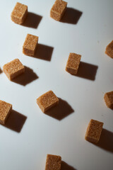 Cubes of cane sugar on a white background with a shadow. Top view.