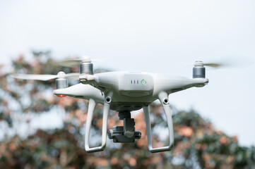 Flying white drone taking pictures of flowers
