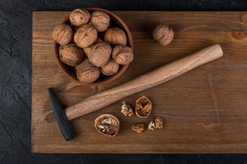 Walnut in a bowl and hammer on a wooden board