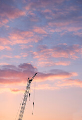 Obraz premium Beautiful sunset clouds sky background and construction crane. inspiration atmosphere image. copy space