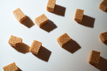 Cubes of cane sugar on a white background with a shadow. Top view.