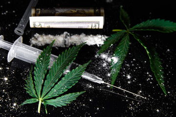 Drug use concept. powder, cannabis, syringe are scattered on a black background. Powder drug addiction