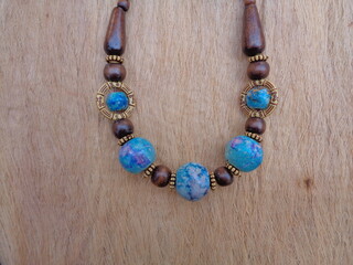 Wooden necklace with brown background. The necklace on the wooden background.