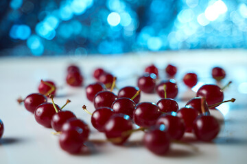 Group of cherry on a white background with shadows. Close-up. Blue Bokeh effect background