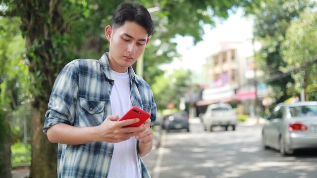 Asian man waiting for Uber taxi