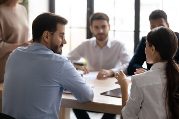 Rear view confident businesswoman speaking, discussing project at corporate meeting, sharing...