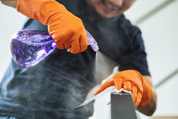 Asian man hand spraying to staircase of house for cleaning by tower in covid19 outbreak and...