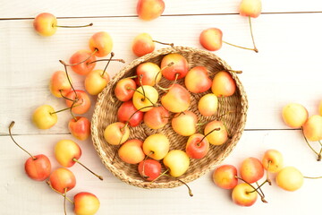 Yellow sweet cherry, close-up, on a white wooden table.