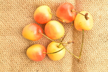Yellow cherry, close-up, on jute fabric